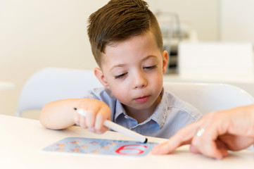 Obraz na płótnie Canvas preschooler child boy learn to write number nine in the classroom