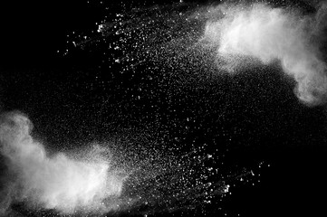 Freeze motion of white dust explosion on black background. Stopping the movement of white powder on dark background. Explosive powder white on black background. - 165842129