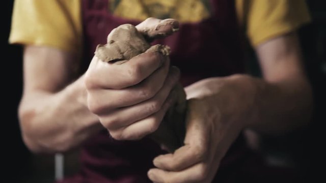 Hands of the master potter and vase of clay on the potter's wheel close-up. Master crock man. Twisted potter's wheel.