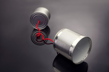phone toy from a tin can lying on a smooth black polished table