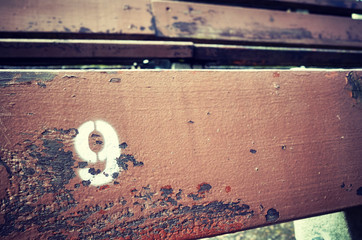Number nine painted on an old wooden seat, conceptual picture with copy space on the right.