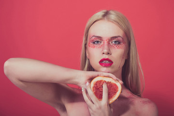 pretty blonde woman with creative fashionable makeup hold grapefruit, vitamin