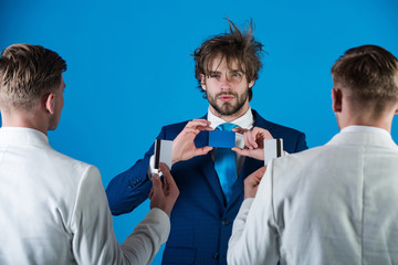 Businessmen exchanging cards on blue background