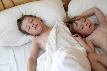 Fototapeta na wymiar Brothers sleeping on bed