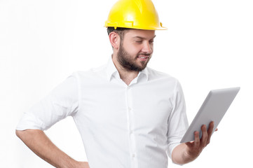 Contractor in yellow builder helmet working on a project with tablet.