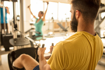 Fit man exercising at the gym on a machine