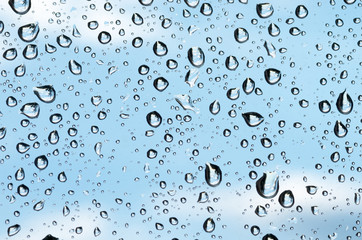 Raindrops on the glass against the blue sky.