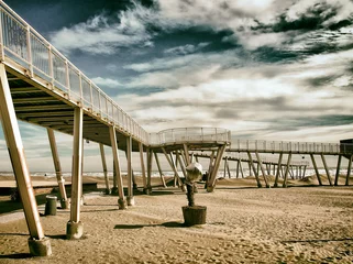 Foto auf Acrylglas beach at the lido in venice with metal modern pier and elevated walkways with dramatic sky sea and sand out of season. © philopenshaw