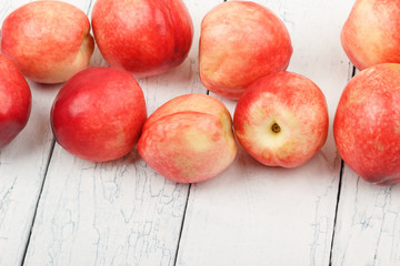 Ripe red peaches on the white wooden table