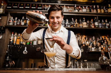 smiling bartender with fancy cocktail - obrazy, fototapety, plakaty