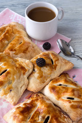 Puff cakes with berries. Puffs with raspberries and apples. Baking with berries and a cup of coffee.