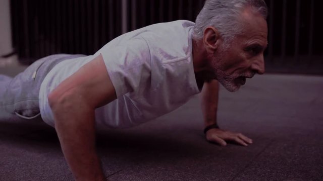 Strong senior man doing press up exercises