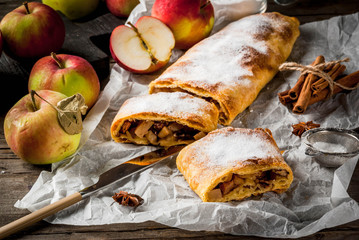 Home autumn, summer baking, puff pastries. Apple strudel with nuts, raisins, cinnamon and powdered...