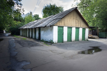 Old wooden bar with grey roof and many green doors