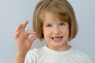 child, kid, shows the fallen baby tooth.