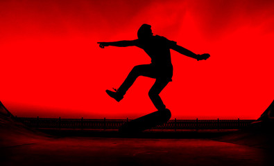 Silhouette of a young skater on a bright red background