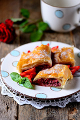 Puff pastry pie with strawberries, nuts and powdered sugar.