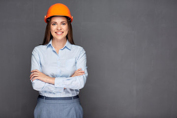 Smiling woman builder wearing safety helmet.