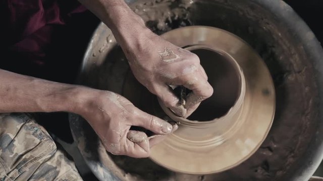 Hands of the master potter and vase of clay on the potter's wheel close-up. Master crock man. Twisted potter's wheel.