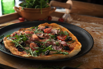 Traditional pizza with prosciutto and arugula