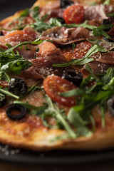 Traditional pizza with prosciutto and arugula