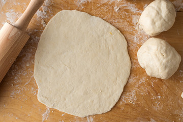Prosciutto pizza preparation on wooden background