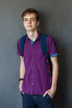 Young cute guy with a backpack isolated on a dark background