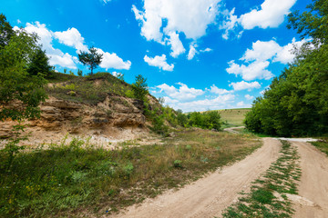 Ground road against green trees, rocks