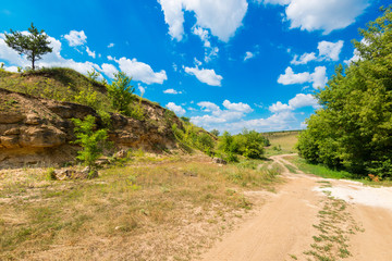 Ground road against green trees, rocks