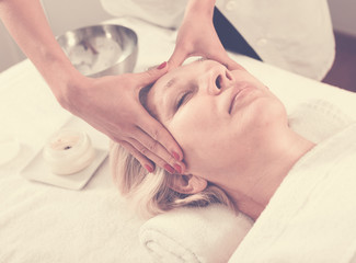 Mature woman having face massage