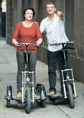 Fototapeta na wymiar couple with electrkc bikes in vacation on city street