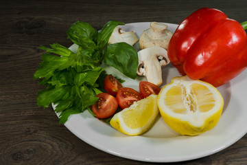 Parsley, lemon, pepper, champignons on a plate