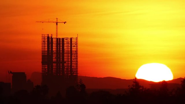 Time Lapse of the Sun rising behind a high-rise construction in Los Angeles.