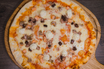 Hot piece of pizza with melted cheese on a rustic wooden table
