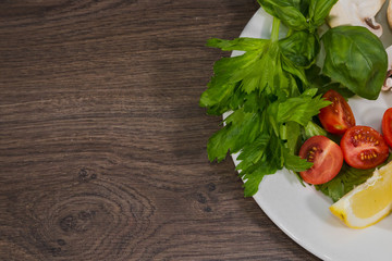 Parsley, lemon, pepper, champignons on a plate