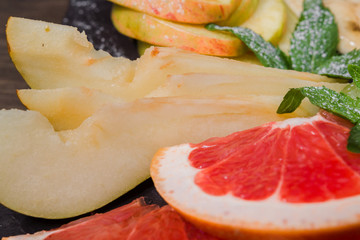 Fruit slicing on a wooden background and on a stone stand