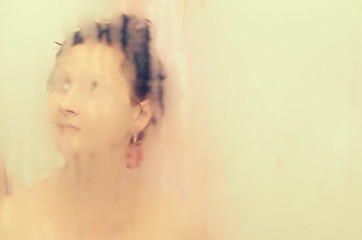 Obraz na płótnie Canvas The girl takes a shower in the bathroom.