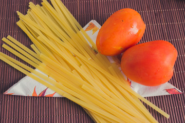 spaghetti with vegetables, tomato, carrot and potato in a wooden table