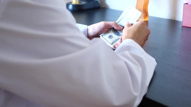 Corruption, bribery and fraud are. a close-up of a doctor taking money. 4k . slow motion