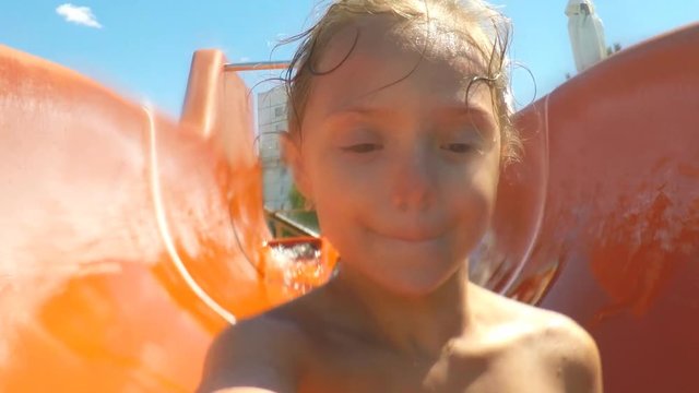 A child on a water slide. Happy little girl on a water slide.