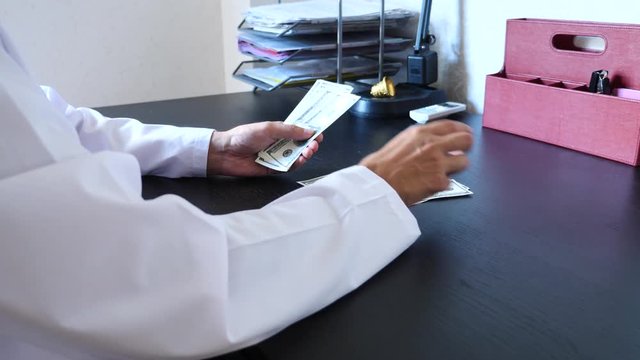 Corruption, bribery and fraud are. a close-up of a doctor taking money. 4k . slow motion