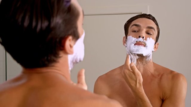 Athletic man shaving in the morning.