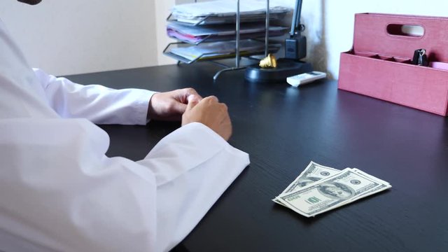 Corruption, bribery and fraud are. a close-up of a doctor taking money. 4k . slow motion