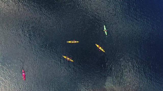 A process of kayaking in the lake skerries, with colorful canoe kayak boat paddling, process of canoeing, vibrant summer picture, shot from drone