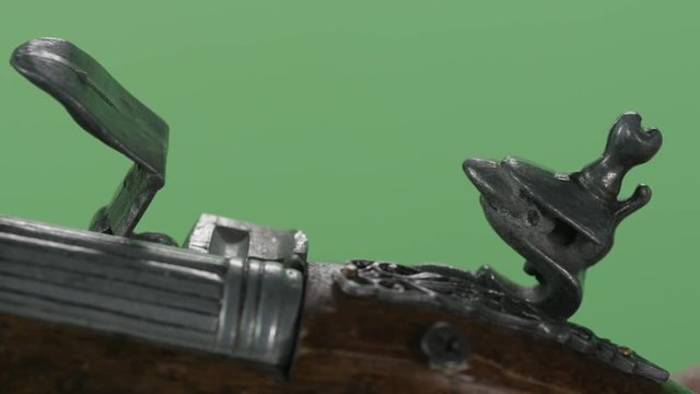 Vintage pistol in hand holding on green background. Vintage antique flintlock pistol isolated on green screen. Shot of vintage gun close up