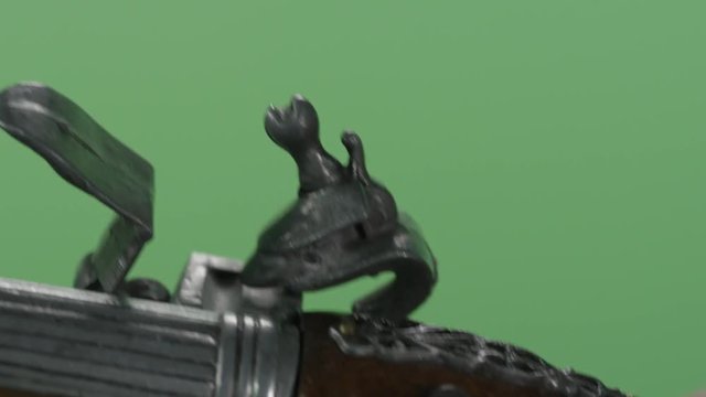 Vintage pistol in hand holding on green background. Vintage antique flintlock pistol isolated on green screen. Shot of vintage gun close up