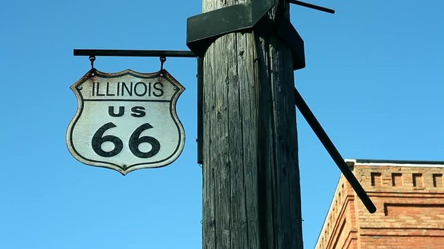 Small Route 66 sign swings in the wind, on the mother road in Illinois  Royalty free stock video