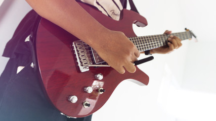 A man playing red electric guitar