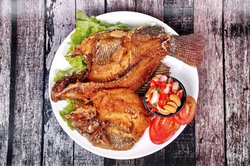 Deep fried Tilapia with spicy and sour herb salad .