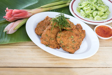 Thai food, fried fish-paste balls on white dish.